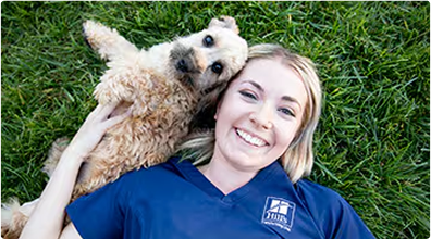 Woman lying with a dog on grass